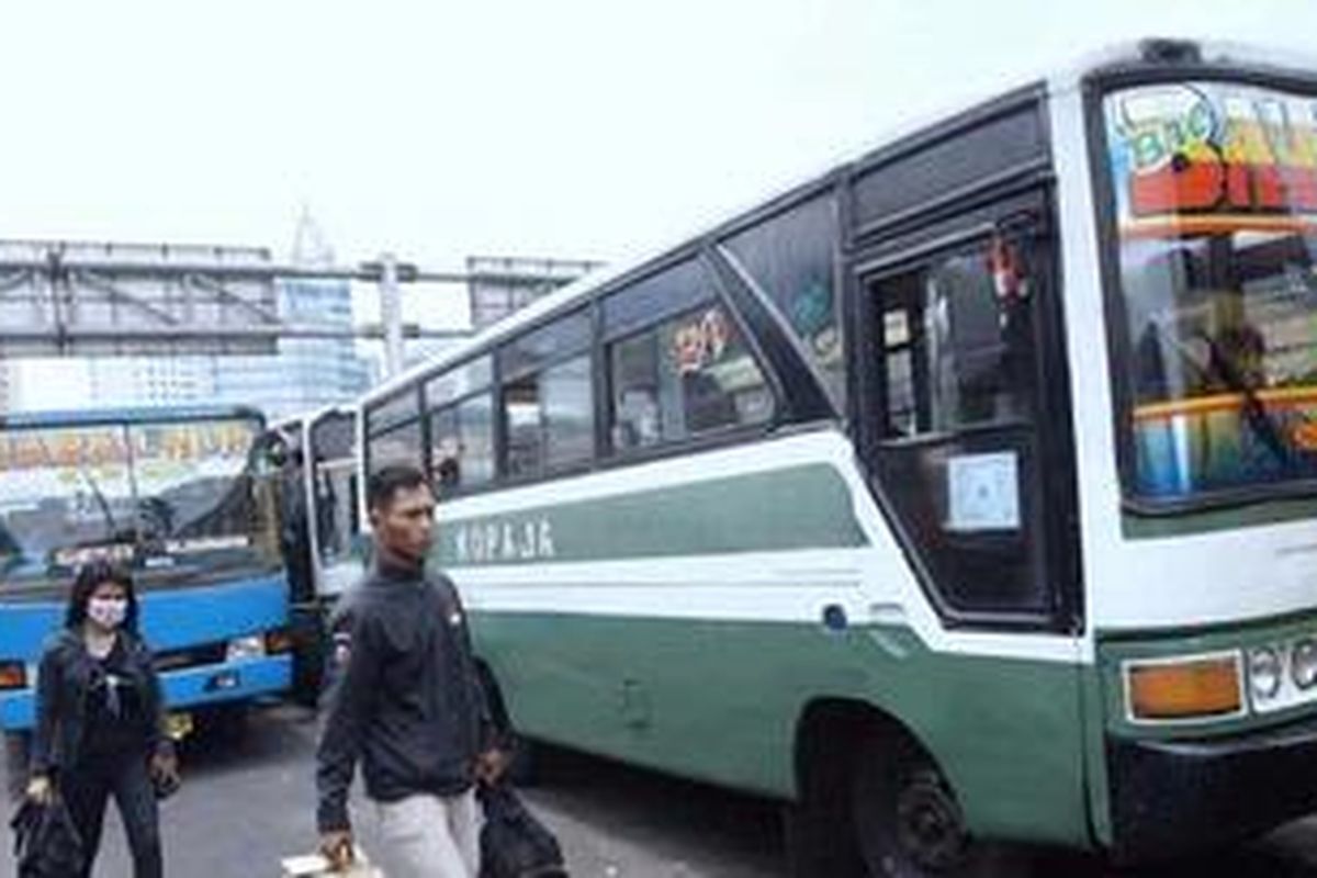 Warga melintas di samping  Kopaja P20 yang menunggu pe numpang di Terminal Pasar Senen, Jakarta Pusat, Kamis (18/10/2012). 