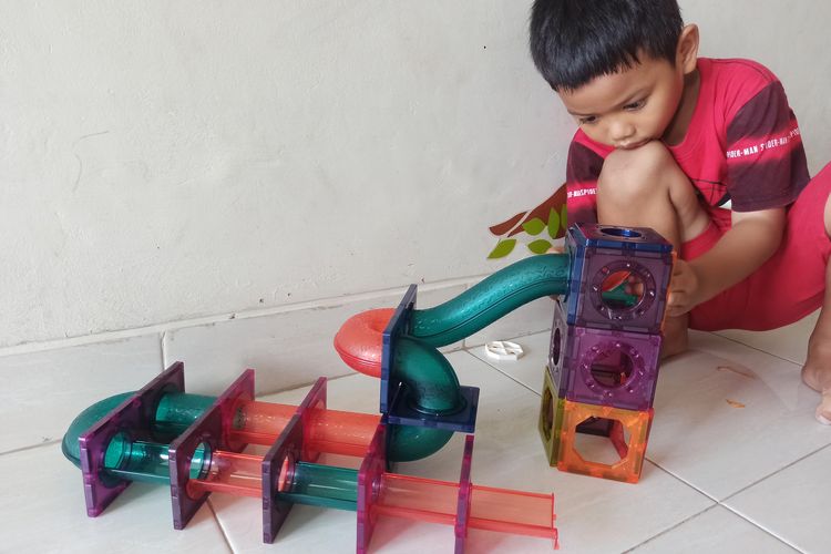 Mainan edukasi dari Toys Kingdom Magnetic Tiles Blocks dimainkan anak dengan membuat model seluncuran bola sesuai kreativitas mereka.