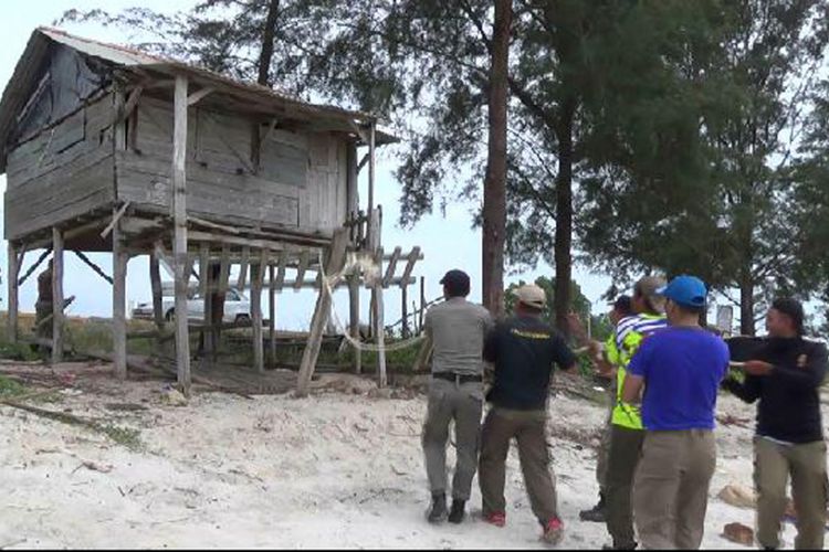 Petugas Pol PP saat berusaha menarik rubuh bangunan liar di pantai Jembatan Emas Selindung, Kepulauan Bangka Belitung.