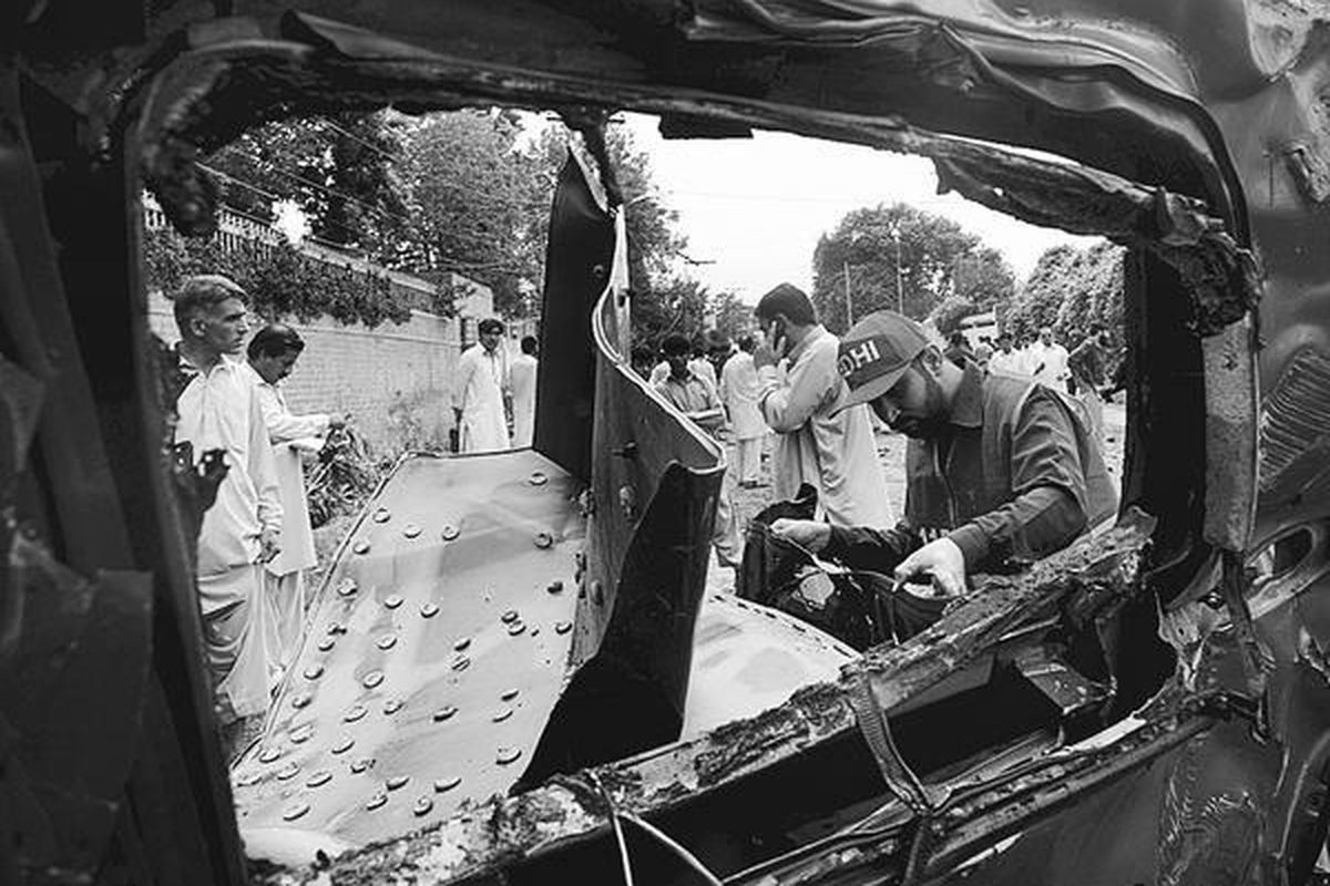 Petugas penyelamat Pakistan memeriksa bangkai kendaraan milik Konsulat AS yang rusak parah terkena ledakan bom bunuh diri di Peshawar, Senin (3/9). Pejabat intelijen Pakistan membenarkan bahwa mobil Konsulat AS itu menjadi sasaran serangan bom bunuh diri tersebut. Namun, pihak Kedubes AS di Islamabad membantah bahwa dua warga AS tewas dalam serangan itu.