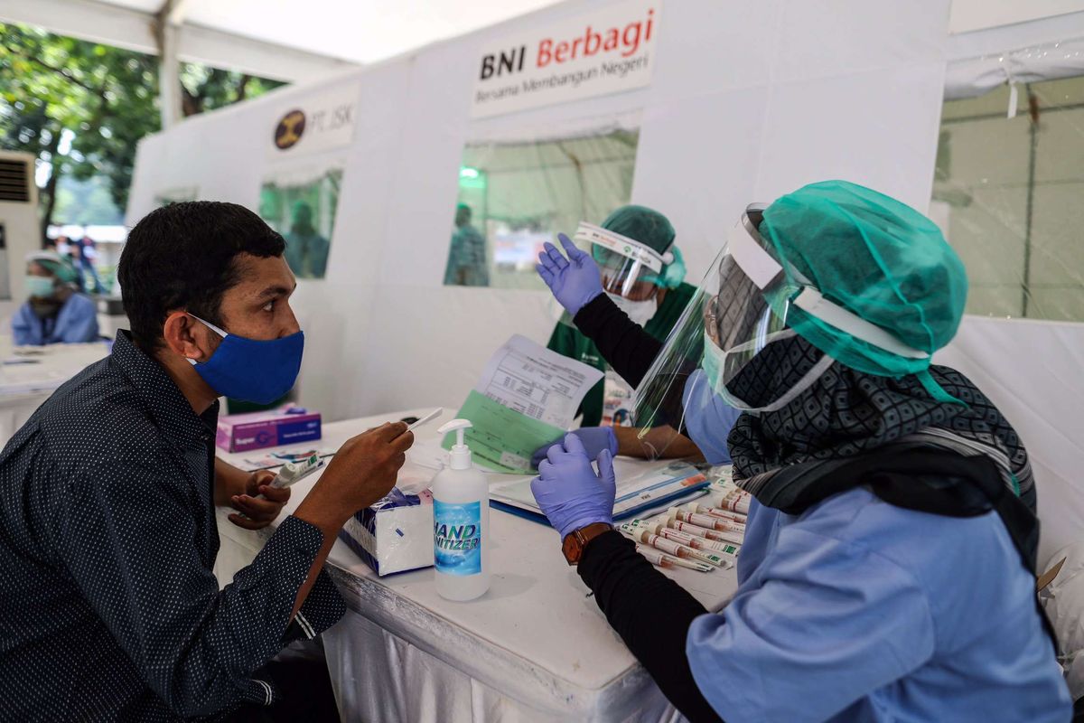 Petugas kesehatan saat melayani warga untuk pengambilan sampel swab lendir tenggorokan dan hidung di halaman parkir selatan, Gelora Bung Karno, Jakarta Pusat, Rabu (20/5/2020). Bank Negara Indonesia (BNI) menggelar kegiatan berupa layanan swab test gratis untuk cegah pandemi yang diakibatkan oleh virus corona (SARS-CoV-2) untuk masyarakat umum dan perawat di Jakarta.