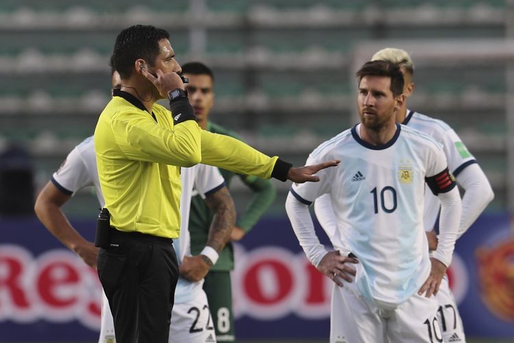 Lionel Messi menunggu keputusan wasit Diego Haro yang mengecek VAR dalam laga Kualifikasi Piala Dunia 2022 zona Amerika Selatan (Conmebol) di Stadion Hernando Siles, Selasa (13/10/2020) atau Rabu dini hari WIB. 