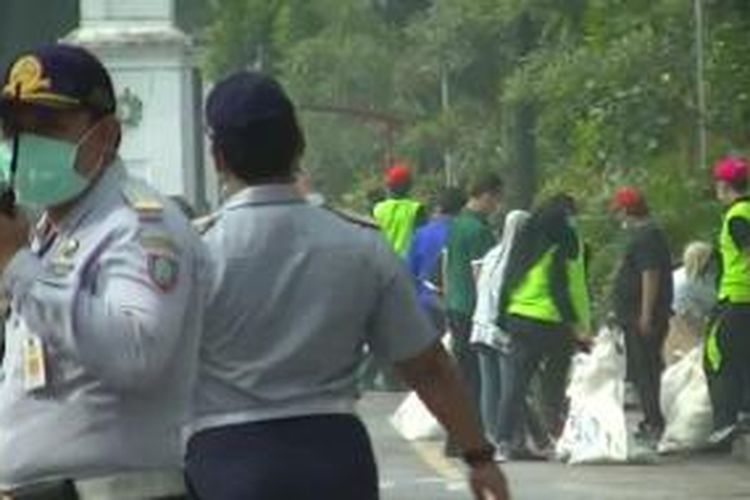 Warga bergotong royong bersihkan abu vulkanik di Jalan Jenderal Sudirman, Senin (17/2/2014). 