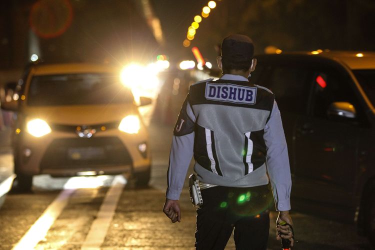 bPetugas melakukan pemeriksaan pada H-1 Lebaran di check point penyekatan pertama di ruas tol Jakarta - Cikampek Km 31, Kabupaten Bekasi, Jawa Barat, Sabtu (23/5/2020). Larangan diberlakukan pemerintah untuk mencegah penyebaran Covid-19 melalui Operasi Ketupat 2020. Kendaraan pribadi baik motor atau mobil dan kendaraan umum berpenumpang dilarang keluar dari wilayah Jabodetabek.