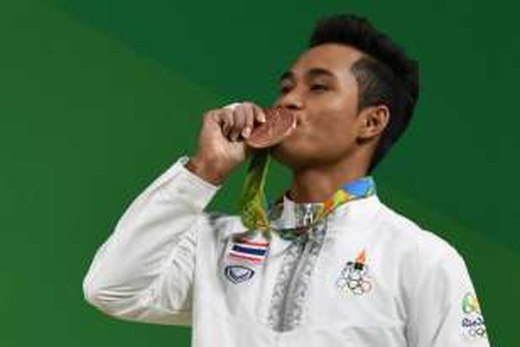 Lifter Thailand, Sinphet Kruaithong, mencium medali perunggu yang dimenangkannya pada kelas 56 kg di cabang angkat besi putra 56 kg pada Olimpiade Rio 2016, Minggu (8/8/2016).