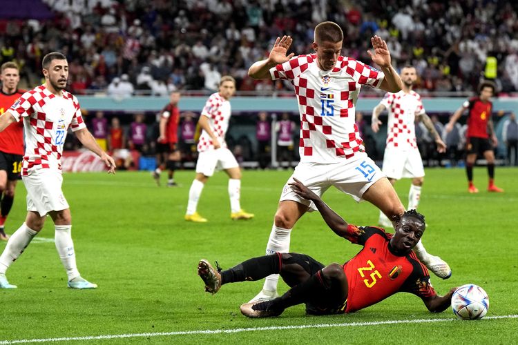 Penyerang Belgia Jeremy Doku (bawah) saat berduel dengan gelandang Kroasia Mario Pasalic di penyisihan Grup F Piala Dunia 2022 antara Belgia vs Kroasia di Stadion Ahmad bin Ali, Qatar, Kamis (1/12/2022).