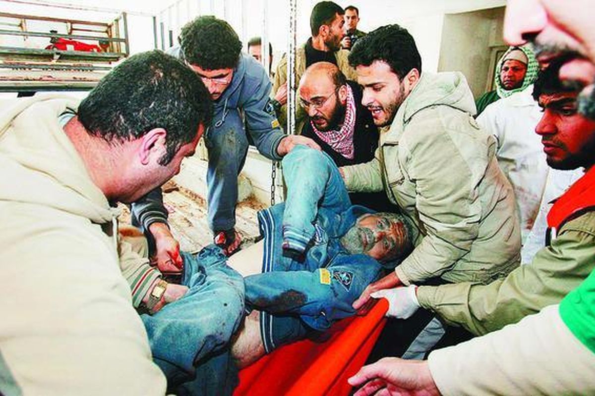 Seorang pria Palestina yang terluka digotong ke rumah sakit, Minggu (4/1). Rudal Israel yang menghantam pusat perbelanjaan utama di Gaza City menewaskan sedikitnya 12 orang dan melukai 40 orang yang semuanya adalah warga sipil Palestina.