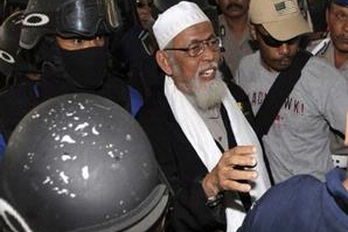 Radical Indonesian cleric Abu Bakar Bashir, center, is escorted by anti-terror police as he arrives at Indonesian police headquarters in Jakarta, Indonesia, Monday, Aug. 9, 2010. Bashir, once imprisoned for his links to the terror group behind the Bali bombings, was arrested Monday for alleged involvement with a new militant network.