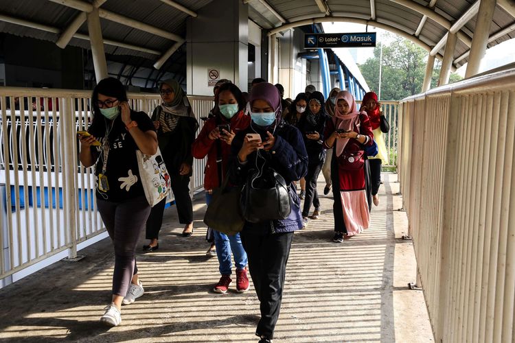 Warga menggunakan masker saat melewati jembatan penyebrangan orang (JPO) dari stasiun Palmerah di Jakarta, Selasa (3/3/2020). Presiden Joko Widodo mengimbau warga untuk tidak panik, tetapi tetap waspada dengan tetap higienis serta menjaga imunitas tubuh usai mengumumkan dua orang Warga Negara Indonesia (WNI) positif terjangkit virus corona yang saat ini dirawat di ruang isolasi RSPI Sulianti Saroso, Jakarta.