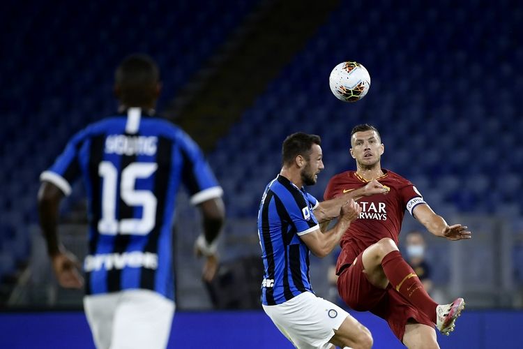 Stefan de Vrij (tengah)  berebut bola dengan Edin Dzeko (kanan) pada laga AS Roma vs Inter Milan di Stadion Olimpico dalam lanjutan pekan ke-34 Serie A, kasta teratas Liga Italia, Minggu 19 Juli 2020.