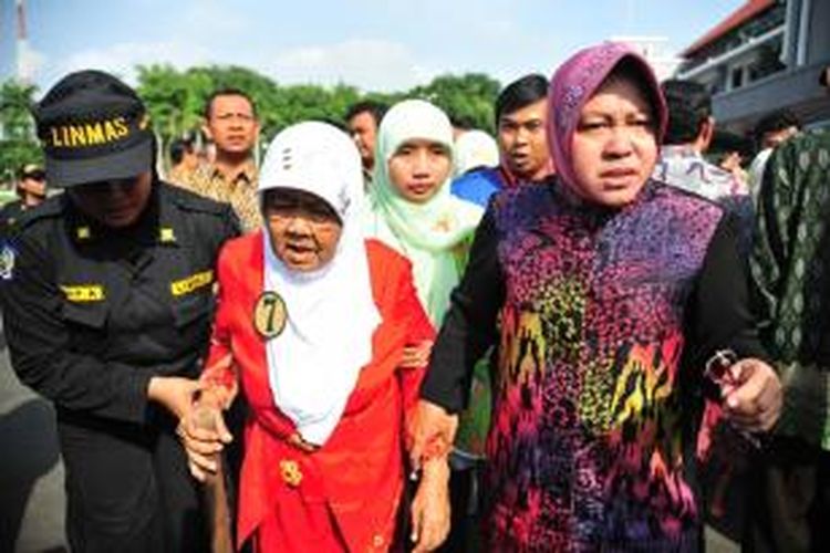 Risma mengantar penyandang PMKS ke mobil.