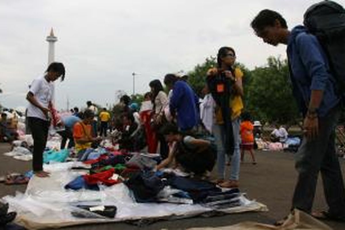 Pedagang kaki lima (PKL) menggelar dagangan mereka di pelataran silang Monumen Nasional di Jakarta, Minggu (14/7/2013). Ratusan PKL menyambut gembira karena mereka bebas berdagang seiring dengan digelarnya Monas Fair untuk menyambut Ramadhan. 