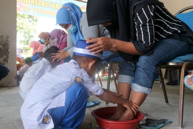 Momen saat anak-anak PAUD dan Kelompok Belajar membasuh kaki ibunya di kawasan Wisata Edukasi Ngusikan (Wedang) di Desa Ngusikan, Kecamatan Ngusikan, Kabupaten Jombang, Jawa Timur, Rabu (22/12/2022).