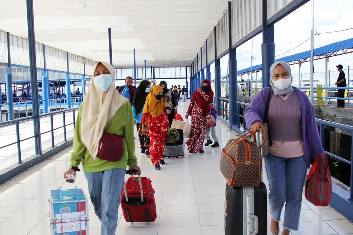 Sejumlah pemudik dari Kepulauan Riau berjalan menuju terminal ketibaan di Pelabuhan Bandar Sri Junjungan Dumai, Riau, Minggu (25/4/2021). Dua pelabuhan di Dumai, Pelabuhan Roro Purnama dan Bandar Sri Junjungan mulai ramai disinggahi pemudik Hari Raya Idul Fitri 2021 dan kedua pelabuhan tersebut digunakan sebagai tempat transit pemudik menuju kampung halamannya seperti ke Pulau Rupat, Sumbar, Jambi dan Sumut. ANTARA FOTO/Aswaddy Hamid/aww. 