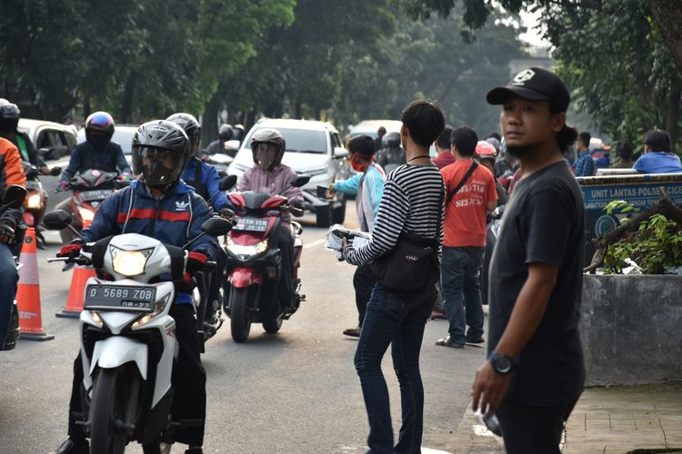 Sejumlah warga menjajakan dagangannya berupa masker dan sarung tangan di pinggir jalan sebelum pemeriksaan petugas di Check Point saat PSBB Jabar diberlakukan, Rabu (6/5/2020).