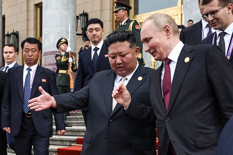 Dalam foto yang didistribusikan oleh badan pemerintah Rusia Sputnik, Presiden Rusia Vladimir Putin (kanan) dan pemimpin Korea Utara Kim Jong Un (tengah) berbincang setelah pertemuan mereka di Beijing pada 3 September 2025. Putin memuji Kim atas peran pasukan Korea Utara dalam perang dengan Ukraina di Kursk, yang disampaikan saat keduanya hadiri parade militer China.