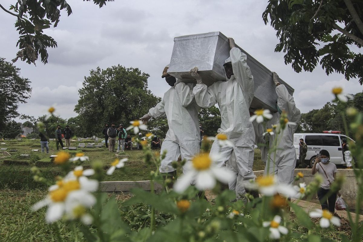 Petugas mengusung peti berisi jenazah yang meninggal dunia karena COVID-19 untuk dimakamkan di TPU Srengseng Sawah, Jakarta, Kamis (14/1/2021). Pemerintah Provinsi DKI Jakarta membuka area pemakaman untuk jenazah COVID-19 di TPU Srengseng Sawah karena Taman Pemakaman Umum (TPU) khusus COVID-19 telah penuh. ANTARA FOTO/Asprilla Dwi Adha/wsj.