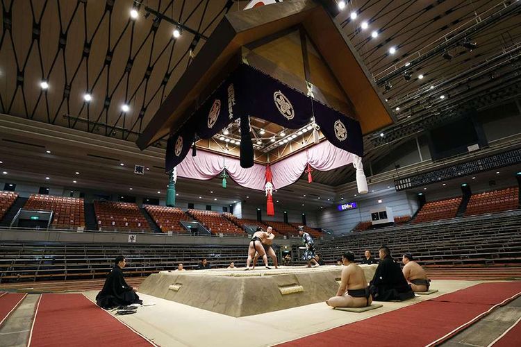 Tempat duduk penonton terlihat kosong saat pertandingan Spring Grand Sumo Tournament yang dilaksanakan di tempat tertutup di tengah-tengah penyebaran virus corona baru, di Osaka, barat Jepang, Minggu (8/3/2020). Kian merajalelanya virus corona (COVID-19) membuat sejumlah kawasan di berbagai belahan dunia yang selama ini dikenal ramai seketika berubah menjadi sepi.