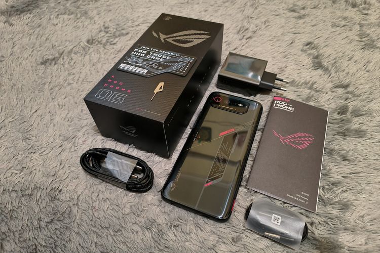 Isi kotak penjualan Asus ROG Phone 6. Ketika membuka kotak penjualan ponsel ini, pembeli tentunya bakal mendapatkan unit ROG Phone 6 dan beberapa kelengkapannya.

Di antaranya seperti kepala pengisi daya alias adapter charger berdaya 65 watt, kabel data USB-C ke USB-C, hardcase dan SIM card ejector khas ROG, serta buku panduan.

Pembeli juga bakal mendapatkan aksesori audio earphone kabel secara cuma-cuma, serta satu buah gimik yang menyerupai kartu. Kartu ini bisa dipindai dengan kamera ROG Phone 6 untuk memainkan game artificial intelligence (AR) bikinan Asus.