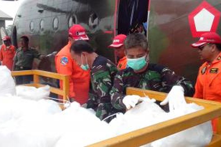 Petugas memasukkan garam yang akan digunakan untuk modifikasi cuaca ke dalam pesawat Cassa 212-200 milik TNI AU di Lanud Supadio (11/8/2015)
