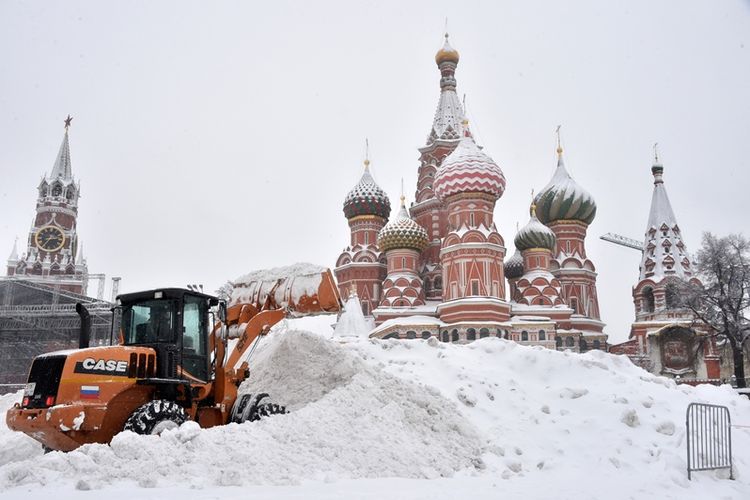 Sebuah bulldozer menyekop salju dari Lapangan Merah saat salju turun di Moskow, Minggu (4/2/2018). (AFP/Mudah Maximov)