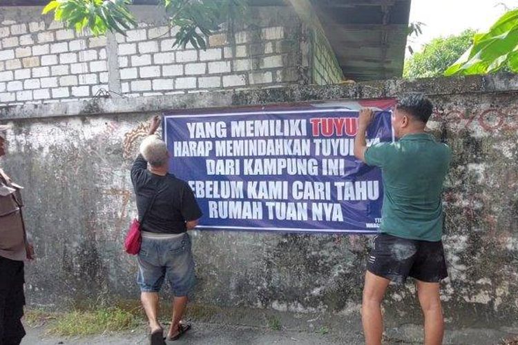 Spanduk yang dipasang Fery Setiawan akhirnya dilepas oleh pemasang dibantu Ketua RT di Gg Glatik, Minggu (25/6/2023) 