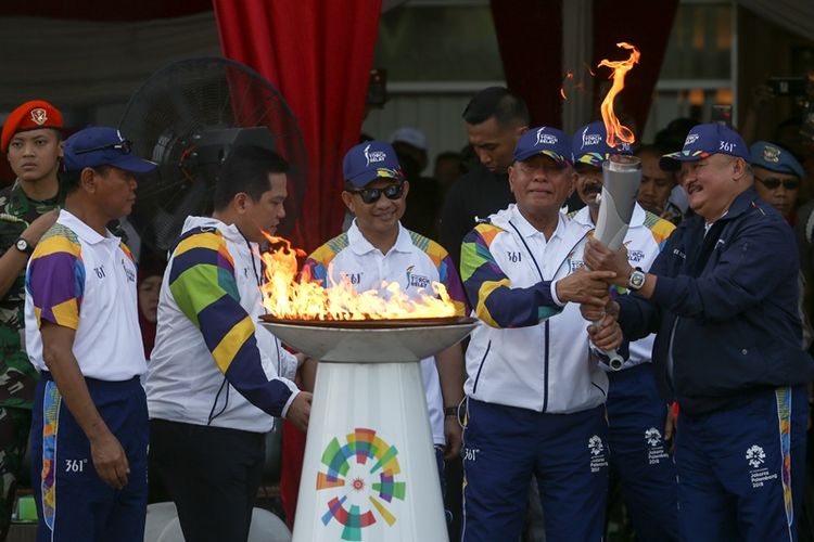 Menteri Pertahanan Ryamizard Ryacudu (ketiga kanan) menyerahkan obor api Asian Games 2018 kepada Gubernur Sumatera Selatan Alex Noerdin (kanan) disaksikan Kapolri Jenderal Pol Tito Karnavian (tengah), Panglima TNI Marsekal Hadi Tjahjanto (kedua kanan), Ketua Umum Inasgoc Erick Thohir (kedua kiri) dan Ketua Panitia Pelaksana Daerah Asian Games 2018 Palembang Muddai Madang (kiri) saat pawai obor api Asian Games 2018 di Jakabaring Sport City (JSC), Palembang, Sumatera Selatan, Sabtu (4/8/2018). Obor api Asian Games 2018 tersebut dibawa mengelilingi kota Palembang dan menyusuri Sungai Musi, selanjutnya akan menuju sejumlah kabupaten/kota yang ada di Sumatera Selatan. 