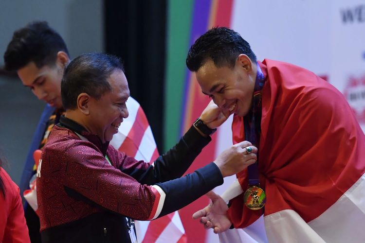 Menpora Zainudin Amali (kiri) mengalungkan medali emas kepada lifter Indonesia Eko Yuli Irawan (kanan) saat upacara penghormatan pemenang final angkat besi nomor 61 kg putra SEA Games  2021 Vietnam di Hanoi Sports Training and Competition Center, Hanoi, Vietnam, Jumat (20/5/2022). Eko Yuli Irawan berhasil meraih medali emas dengan total angkatan ''snatch'' dan ''clean and jerk'' seberat 290kg.