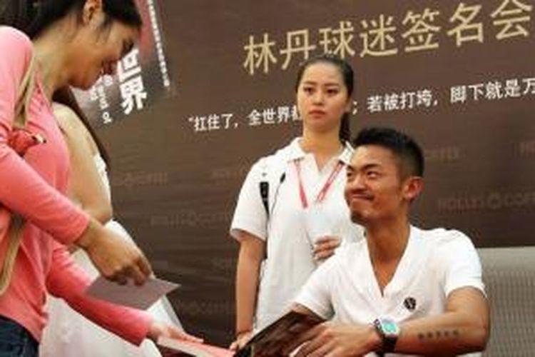 Pebulu tangkis China, Lin Dan (kanan) memberikan tanda tangan pada salah satu penggemarnya, di Shenzen, China, Selasa (26/11/2013).