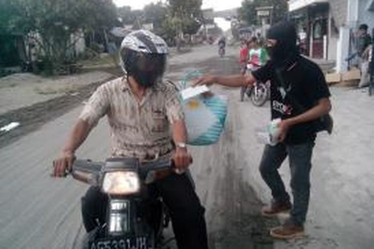 Salah satu klub otomotif Honda Classic Club Indonesia Kediri, saat membagikan masker bagi korban erupsi Gunung Kelud di Plosoklaten, Sabtu (15/2/2014).