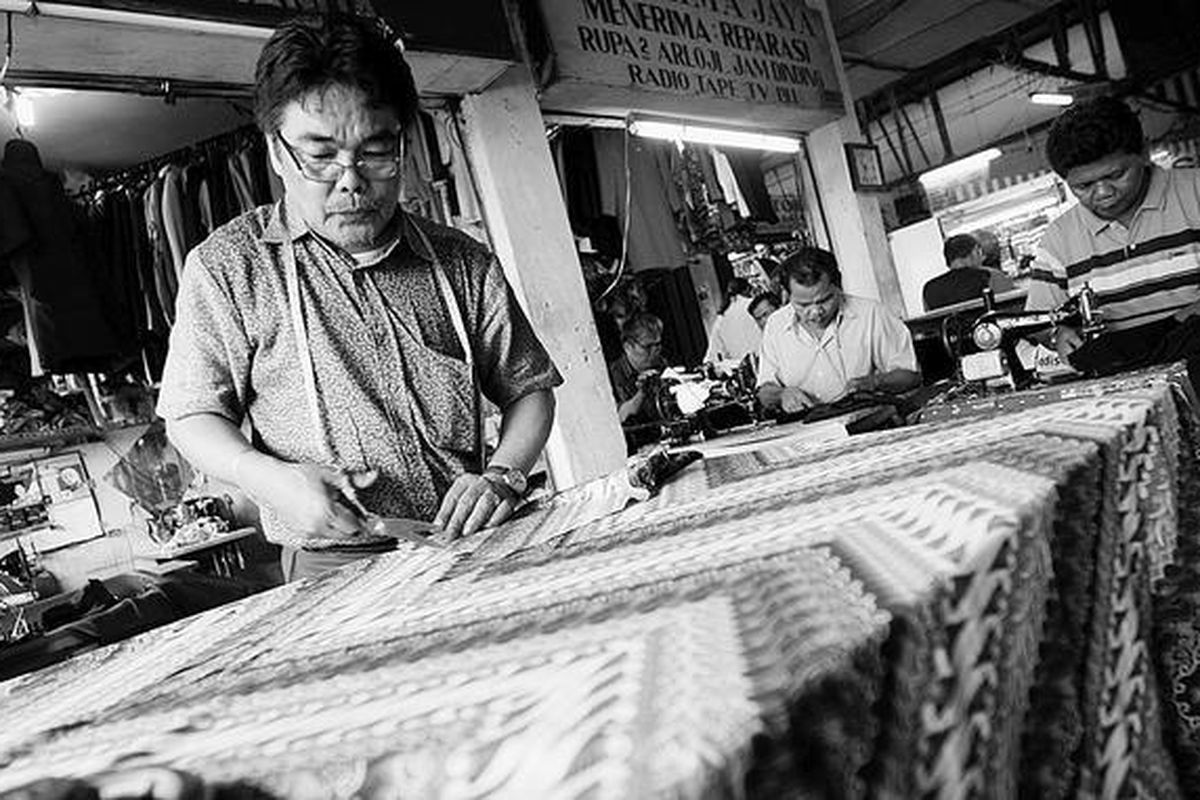 Wirya membuat pola baju batik di kiosnya di Pasar Mayestik, Jakarta Selatan, Jumat (9/10). Pascapengakuan batik sebagai warisan dunia oleh UNESCO, pesanan pakaian berbahan batik meningkat. Dalam sehari, Wirya bisa mendapatkan pesanan 80 potong pakaian batik.