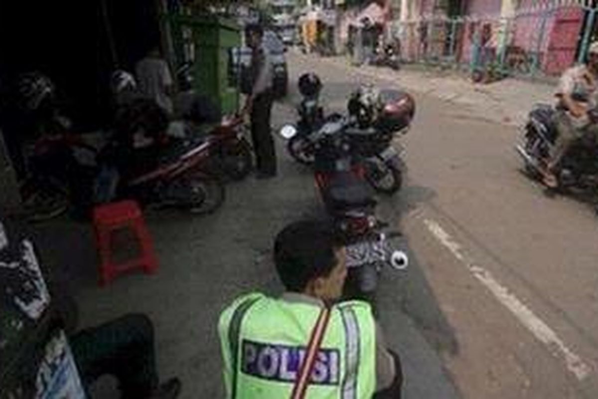 Polisi tampak berjaga di sejumlah titik di sudut jalan di kawasan Tanah Tinggi, Johar Baru, Jakarta, April 2011 lalu. Pascatawuran antarwarga, Polsek dan camat Johar bekerja sama untuk melakukan tindakan preventif dengan menempatkan petugas kepolisian dan kecamatan di sejumlah titik rawan.  