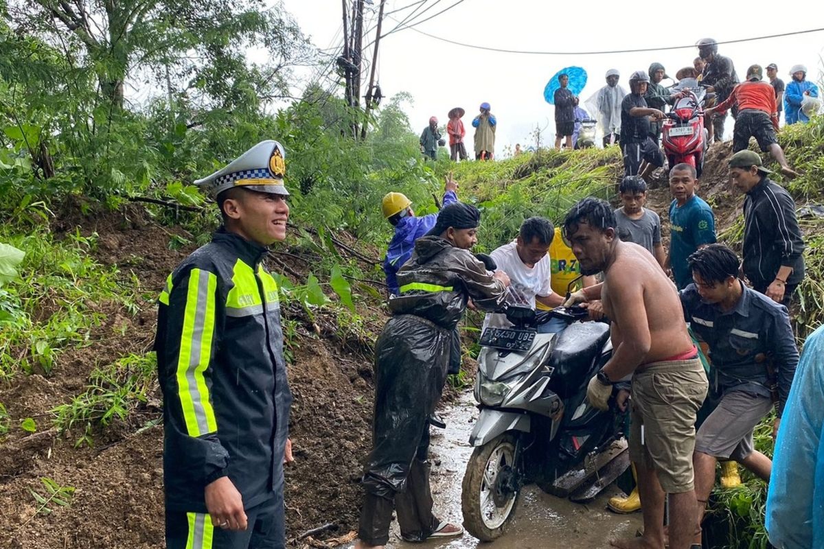 Proses evakuasi sepeda motor melintasi jalan tertimbun longsor di Jalan Raya Cibadak - Palabuhanratu, Desa/Kecamatan Bantargadung, Sukabumi, Jawa Barat, Rabu (4/12/2024).