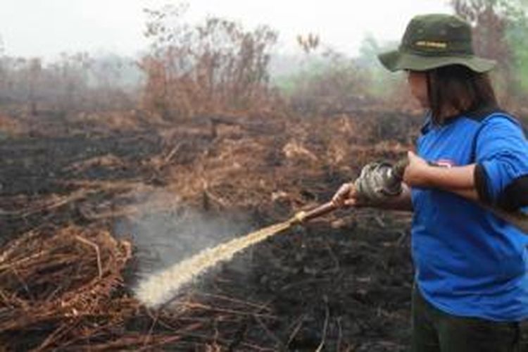 Miki Stevania, salah seorang anggota Manggala Agni Daops Singkawang melakukan pemadaman kebakaran hutan di Desa Telok Ampening, Kecamatan Terentang, Kubu Raya, Kalbar, Jumat (25/9/2015).