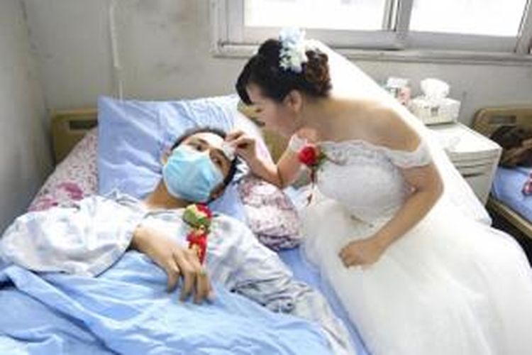 Huang Ye (19) dengan mengenakan gaun pengantin lengkap serta seikat bunga mawar menggelar pernikahan kejutan di ruang perawatan di sebuah rumah sakit di kota Leshan, China dengan kekasihnya Wang Jiangwen (25) yang menderita leukemia.