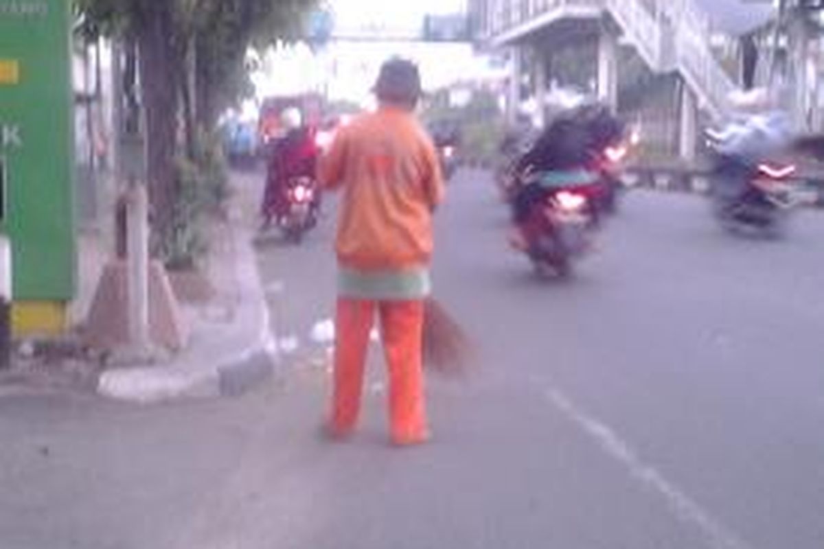 Salah satu petugas penyapu jalan di Mampang Prapatan, Jakarta Selatan, Selasa (19/8/2014).