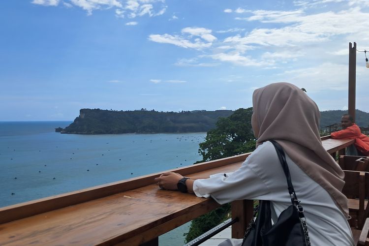 Seorang wisatawan sedang menikmati pemandangan Pantai Sine Tulungagung dari Rooftop salah satu kafe 