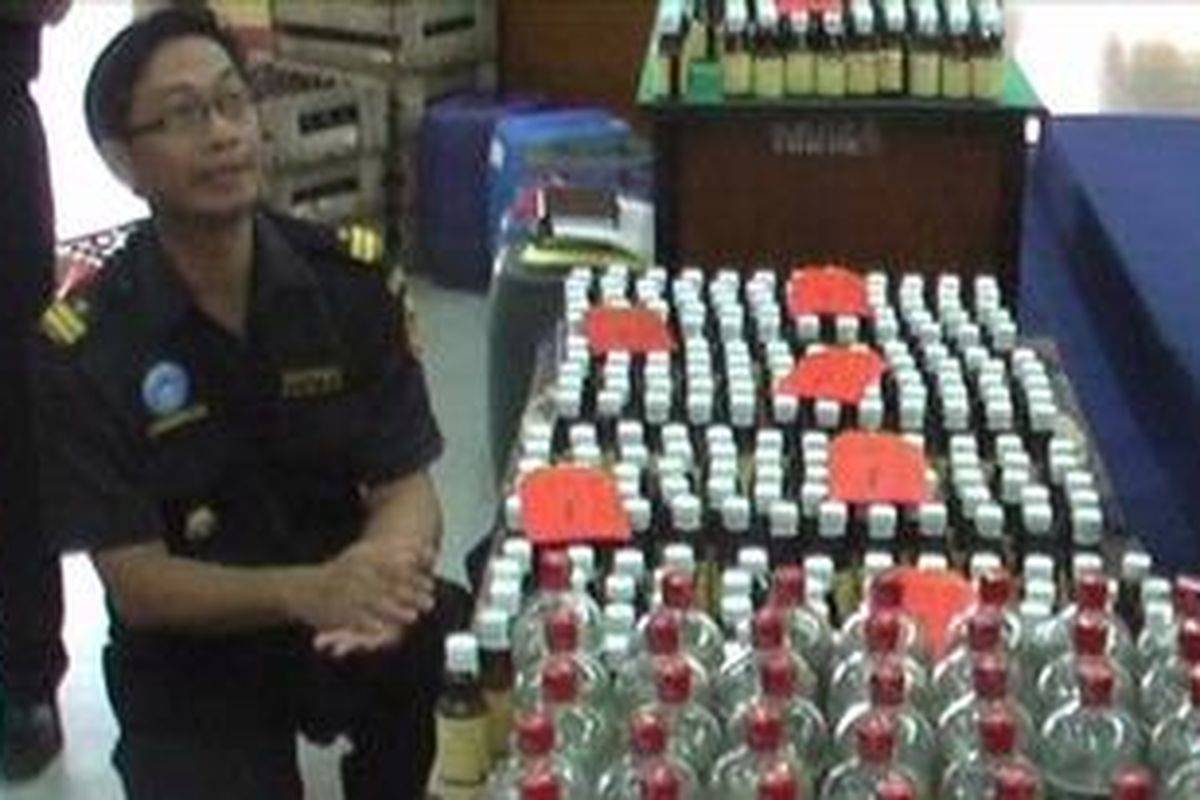 Petugas Bea Cukai Kediri, Jawa Timur menjelaskan kandungan alkohol pada miras yang disita dari produsen miras ilegal, Selasa (14/2/2012).  