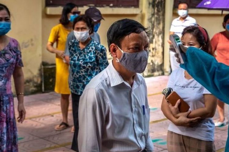 Dalam foto yang diambil di ibu kota Vietnam, Hanoi, orang-orang yang baru dari Da Nang mendapatkan tes Covid-19 setelah terjadi lonjakan kasus di sana.
