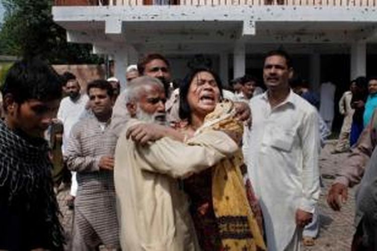 Warga Kristen Pakistan meratapi keluarga mereka yang tewas dalam ledakan dua bom bunuh diri di sebuah gereja di Peshawar, Pakistan, 22 September 2013. Sebanyak 60 orang tewas dalam ledakan dua bom bunuh diri di gereja bersejarah tersebut.