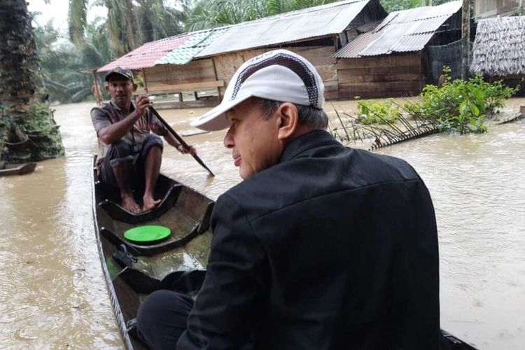 Bupati Aceh Tamiang Mursil menggunakan sampan saat menyusuri wilayah banjir di Kampung Perupuk, Kecamatan Bandar Pusaka, Aceh Tamiang, Kamis (6/1/2022).