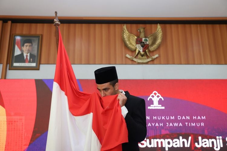 Otaviano Dutra mencium bendera merah putih usai disumpah menjadi WNI di kantor Kemenkumham Jatim, Jumat (27/9/2019)