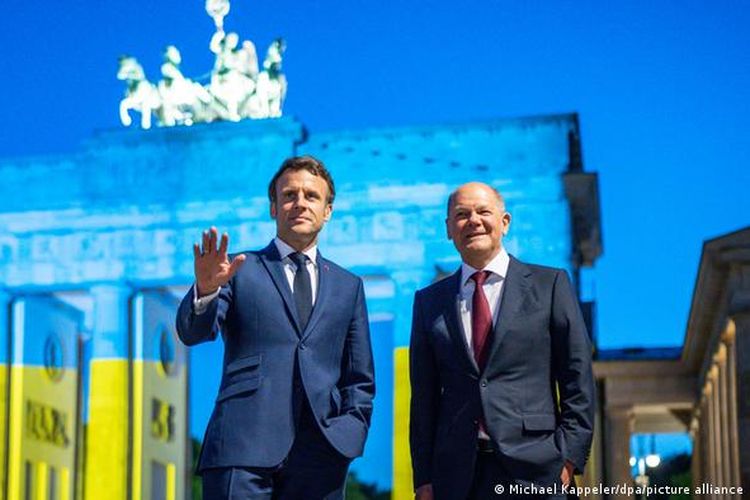 Presiden Perancis Emmanuel Macron (kiri) bersama Kanselir Jerman Olaf Scholz (kanan) di depan Gerbang Brandenburg, Berlin, Senin (9/5/2022).