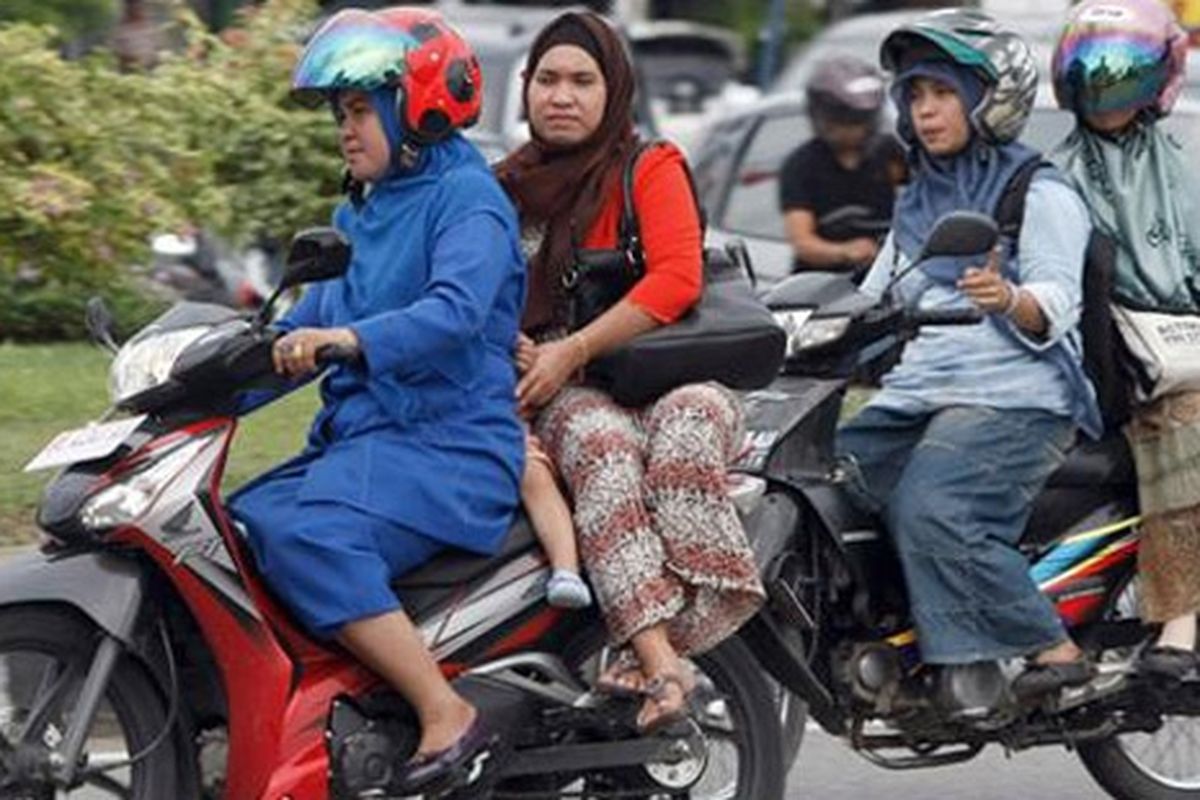 Wanita penumpang sepeda motor diarang duduk mengangkang di Aceh.