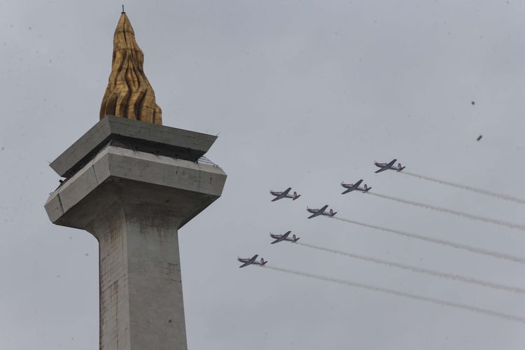 Atraksi udara  tim aerobatik Jupiter dari TNI Angkatan Udara saat perayaan HUT ke-77 TNI di atas Monumen Nasional, Jakarta, Rabu (5/10/2022).