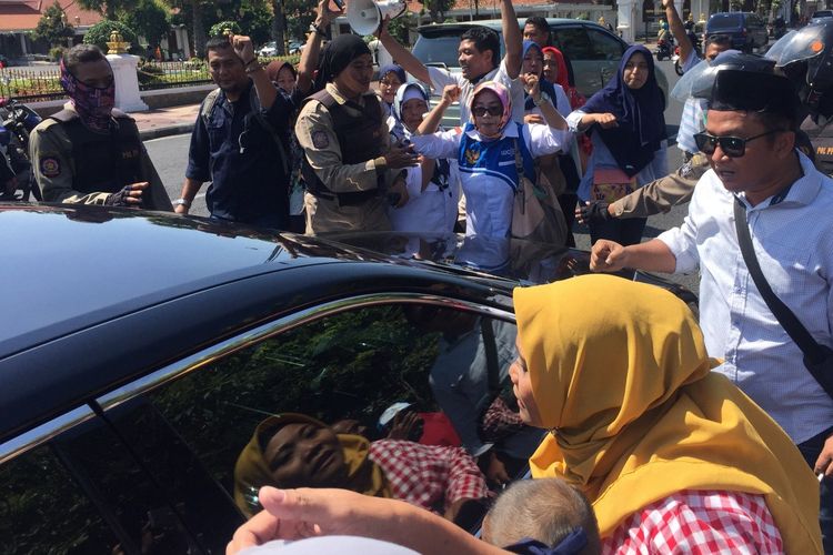 Pengunjuk rasa ibu-ibu rumah tangga hadang mobil dinas di depan gedung negara Grahadi Surabaya, Rabu (19/6/2019)