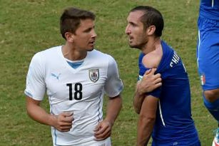 Bek tim nasional Italia, Giorgio Chiellini (kanan), menunjukkan bagian belakang bahu kirinya yang digigit penyerang Uruguay, Luis Suarez (tidak tampak), pada laga pamungkas Grup D Piala Dunia, di Estadio Das Dunas, Natal, Selasa (24/6/2014).