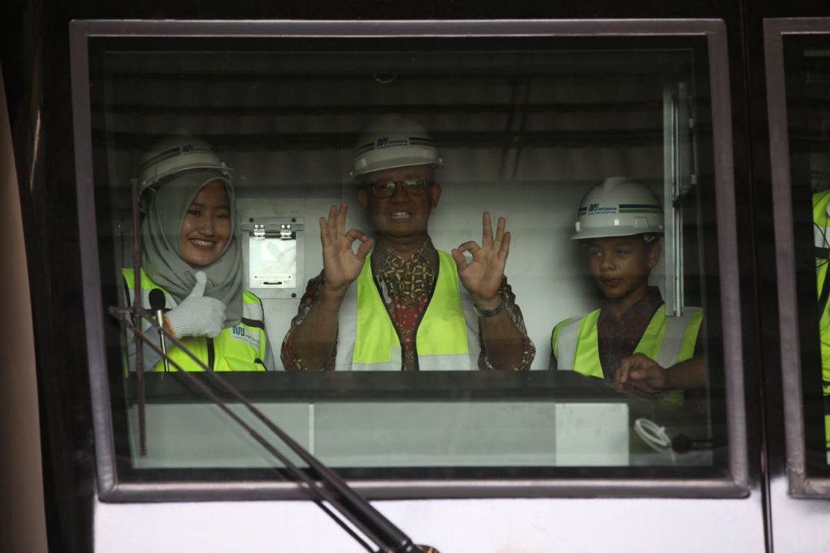 Gubernur DKI Jakarta Anies Baswedan bersama putranya Kaisar Baswedan (kanan) melihat kereta mass rapid transit (MRT) di Depo MRT Lebak Bulus, Kamis (12/4/2018).