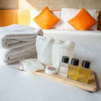 Ilustrasi sampo, sabun, dan handuk hotel.