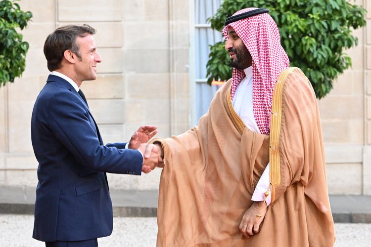 Presiden Perancis Emmanuel Macron bersalaman dengan Putra Mahkota Arab Saudi Mohammed bin Salman atau Pangeran MBS di Istana Presiden Elysee, Paris, 28 Juli 2022. Penerimaan Perancis atas kunjungan MBS dikecam oleh para aktivis HAM dan tunangan Jamal Khashoggi.